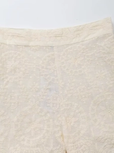 Gros plan sur la broderie florale sur un tissu en coton et lin de couleur crème