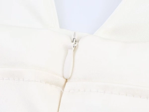 Close-up of invisible zipper detail and fine twill fabric on white strap top