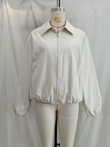 Front view of a white zip-up collared jacket with side pockets and elastic hem on a mannequin