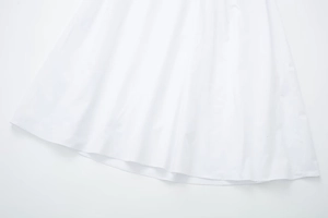 Detail of flared white midi dress hem made of premium crisp cotton poplin fabric