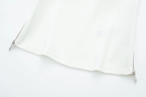 Detail view of smooth white fabric hem with premium silver metal zipper accents