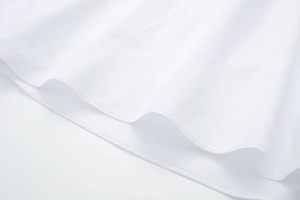 Detail of fine double-stitched hem on a white poplin midi dress with clean seams