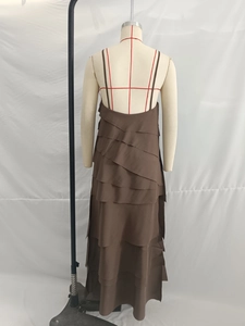 Detail of brown tiered maxi dress featuring layered chiffon fabric and open back design