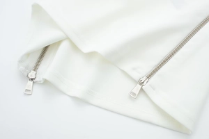Close-up of white knitted fabric detail with dual silver metal zippers and premium stitching