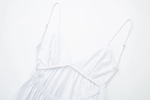 Detailed view of white poplin midi dress featuring slim adjustable straps and open back