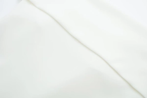 Close-up of premium white satin fabric showing soft texture and elegant silk-like draping