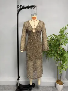 Détail de robe à paillettes avec décolleté en V plongeant et boucle en métal doré