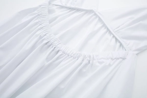 Detail shot of white poplin midi dress featuring elastic pleated back design