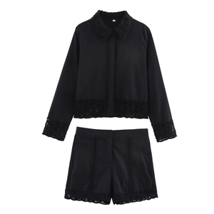 Detailed close-up of intricate crochet lace edges on black two-piece shorts and shirt set