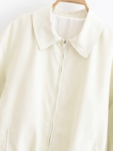 Detailed view of the lapel and metal zipper closure on this cream fashion jacket