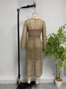 Détail des paillettes scintillantes sur robe en maille à manches longues effet doré