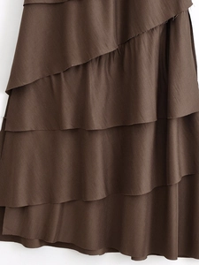 Detailed macro view of dark brown tiered layers on a lightweight woven spring dress