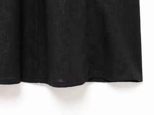 Detailed macro view of the black linen blend fabric texture and hem stitching quality