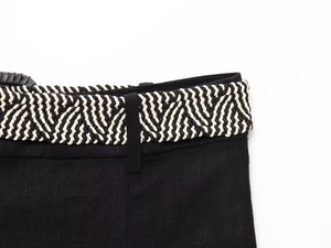 Detail of linen blend dress featuring a black and white braided rope belt texture