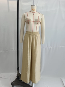 Detail of waist elastic band on beige wide-leg cotton linen trousers for women