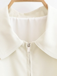 Detail of metal silver zipper and lapel collar on a cream white fashion jacket