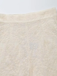 Détail de broderie florale ivoire et dentelle ajourée sur un tissu de haute qualité