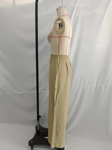 Detail of high-waist linen-textured wide-leg trousers in khaki with elastic waistband