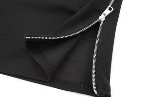 Detailed macro view of the silver metal zipper and stitching on this black knit top