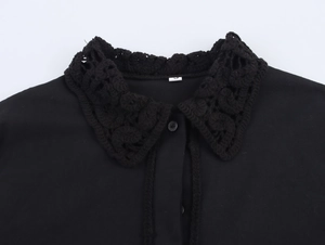 Detailed view of intricate black crochet lace trim on neckline of this women's shirt