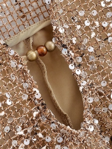 Détail de robe en maille kaki avec sequins argentés et perles de bronze vintage