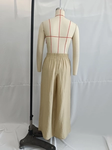 Macro detail of beige high waist wide leg trousers with textured fabric and elastic waist