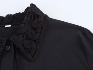 Detailed macro view of the intricate crochet neckline and buttons on this black shirt
