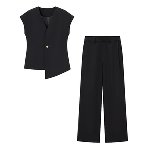 Détail du gilet noir à col en V avec ourlet asymétrique et pantalon large assorti