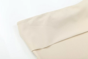 Macro shot of beige zipper top showing the premium twill weave fabric texture and detail