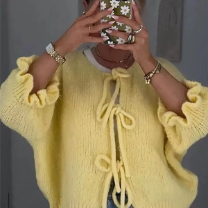 Yellow chunky knit cardigan with bow tie closures and ruffled cuffs for women