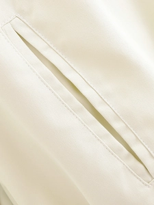 Detailed close-up of beige twill fabric with double-stitched pockets and premium texture