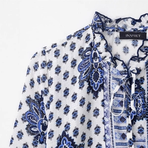 Women's blue and white boho print blouse with ruffle neck and tie detail