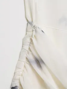 Dettaglio della cerniera invisibile laterale e arricciature su abito in chiffon stampato