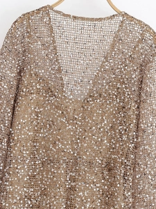 Gros plan détaillé des paillettes dorées sur une robe de soirée en maille élégante