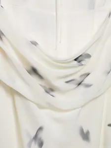 Vista macro della trama in chiffon bianco con stampa astratta di piume nero inchiostro