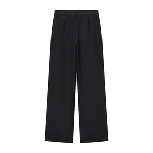 Détail d'un pantalon large noir avec plis sur le devant et passants de ceinture ajustés
