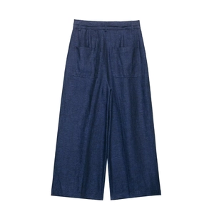 Close-up of linen fabric texture and rear patch pockets on navy blue wide leg trousers