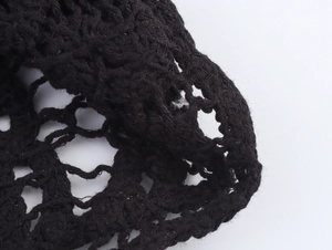 Close-up of black crochet knit fabric with intricate hollow mesh texture for women clothing