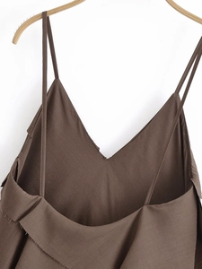 Detail of thin spaghetti straps and deep V-neckline on a dark coffee cotton-linen dress