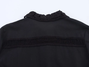 Detail of black shirt featuring intricate crochet lace collar and cutout back design