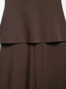 Vue détaillée de l'ourlet superposé et du tissu sergé sur une robe bustier marron foncé