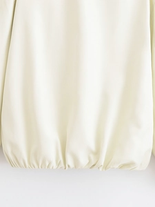 Detailed close-up of cream jacket elastic hem featuring premium woven fabric and neat stitching