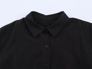Detail shot of the pointed collar and black buttons on a double-layer short sleeve shirt