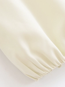 Detailed macro view of elasticated cuffs on a beige minimalist fashion jacket for women