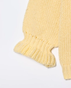 Close-up of knit sweater cuff featuring ribbed design and delicate ruffled edges