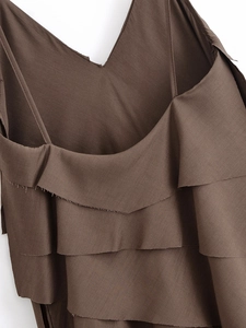 Detailed view of dark brown tiered dress with thin straps and ruffled layering design