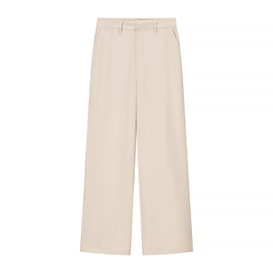 Détail du pantalon large beige clair à taille haute avec tissu fluide et élégant