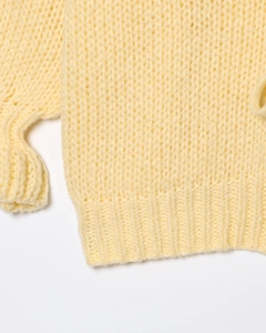 Close-up of pale yellow knit cardigan showing chunky mohair texture and ribbed hem detail