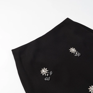 Détail du tissu noir avec des décorations élégantes en strass en forme d'étoile sur la robe