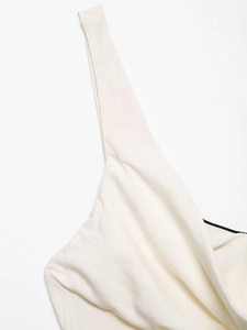Detail of white midi dress showing honeycomb knit texture and one-shoulder strap design